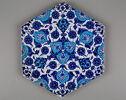 a tile decorated with dark and light blue floral and leaf designs.