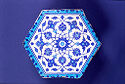 A tile decorated with repeating flora patterns in several shades of blue.