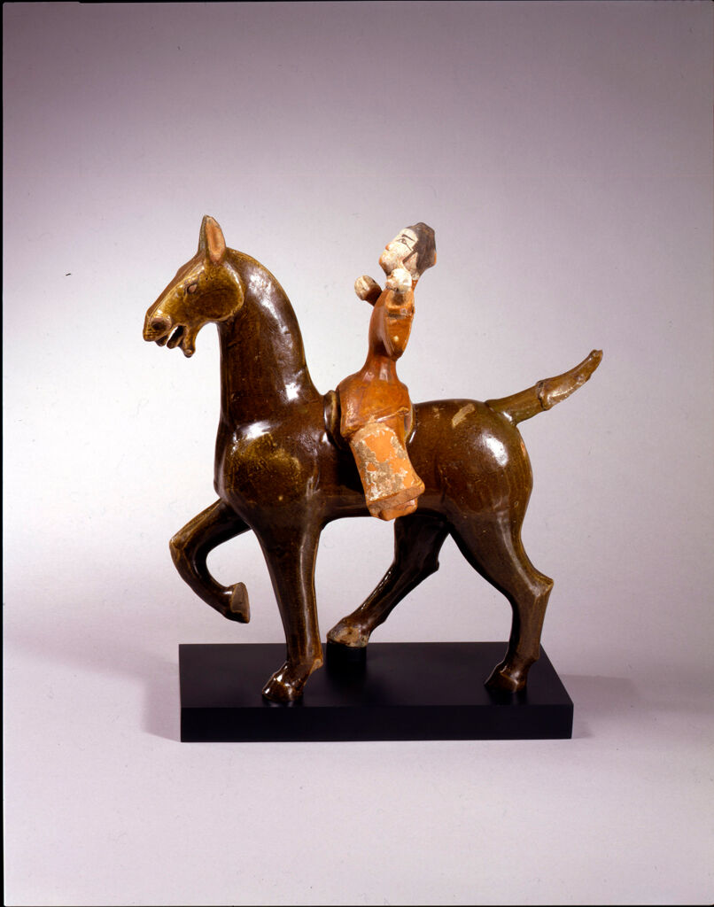 Equestrian Male Figure Positioned To Shoot A Bow And Arrow, And Mounted On A Saddled, Prancing Horse