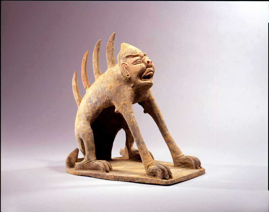 Pair Of Guardian Creatures With Spiked Spines, One With A Human Face, One With A Feline Face