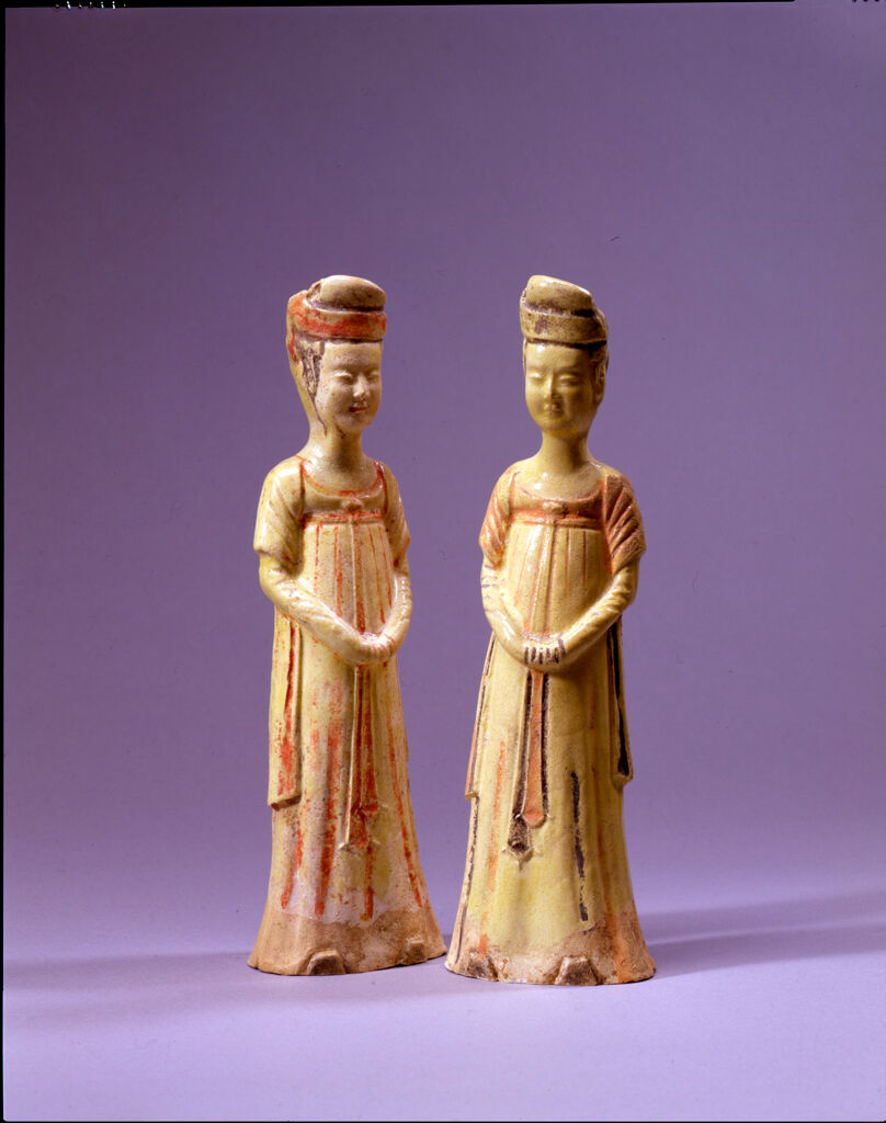 Two Standing Court Ladies, Each With Upturned Shoes, A High-Waisted Dress Or Skirt, A Shawl, And An Elaborate Coiffure Secured By A Headband, And Each With Her Hands Clasped At The Waist And Concealed Within Her Sleeves