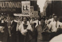 A black and white photograph of a group of demonstrators in an urban landscape.