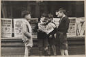 A black and white photograph of four boys standing in front of a store.