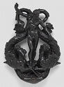 Black brass door knocker in form of nude man with two sea horses.