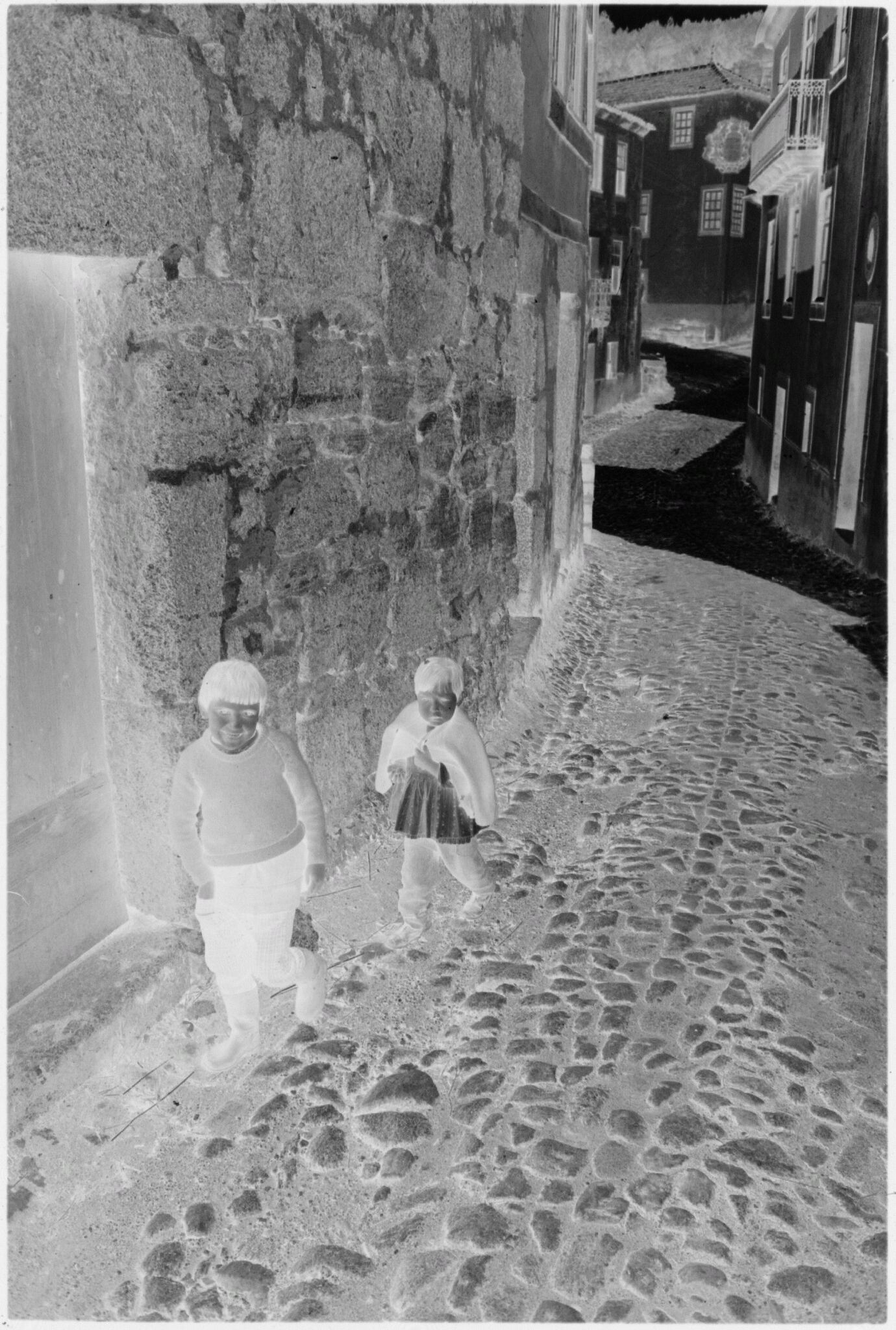 Untitled (Two Young Children Standing Near Doorway In Cobblestone Street, Nazaré, Portugal)