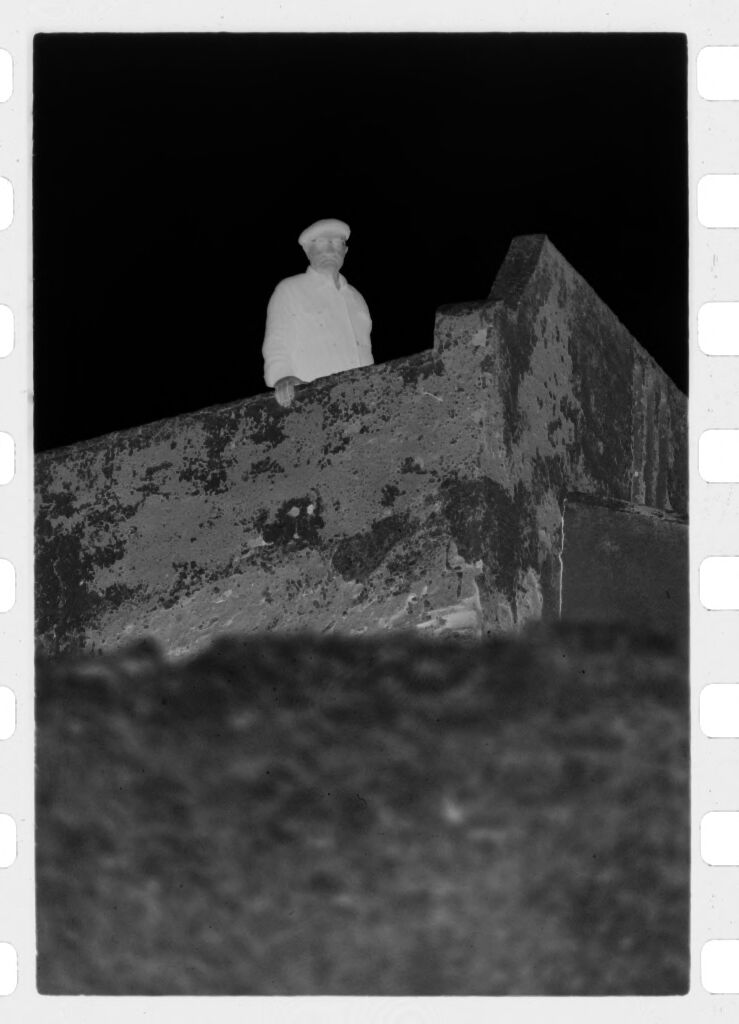 Untitled (Man Standing Behind High Wall, Nazaré, Portugal)