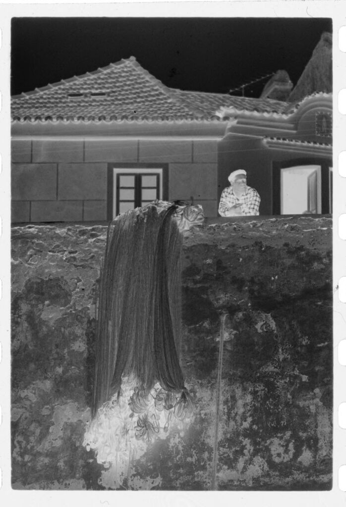 Untitled (Man Leaning Against Ledge Next To Hanging Fishing Nets, Nazaré, Portugal)