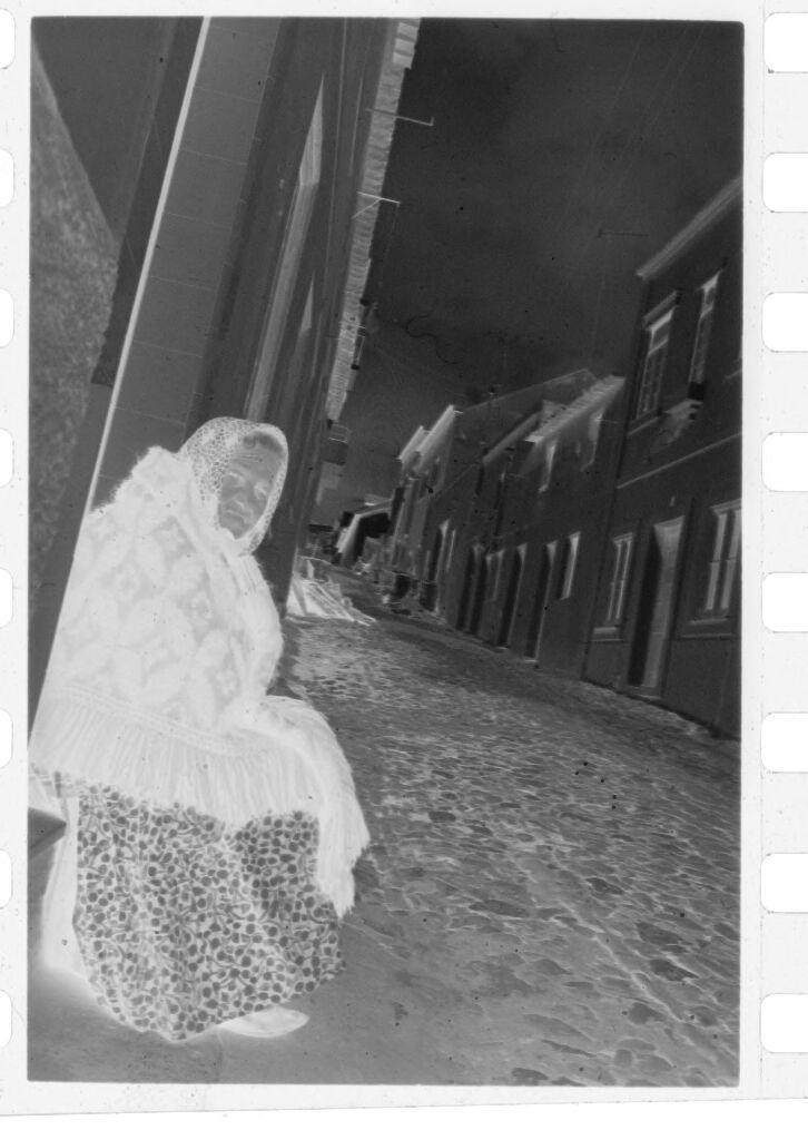 Untitled (Old Woman Wrapped In Shawl Sitting Against Building, Nazaré, Portugal)