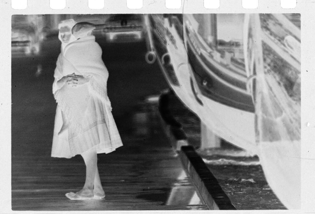 Untitled (Woman Carrying Child Standing In Street Next To Boats, Nazaré, Portugal)