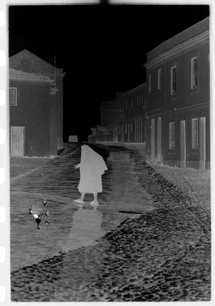 Untitled (Woman Wrapped In Shawl Walking Through Deserted Street, Nazaré, Portugal)