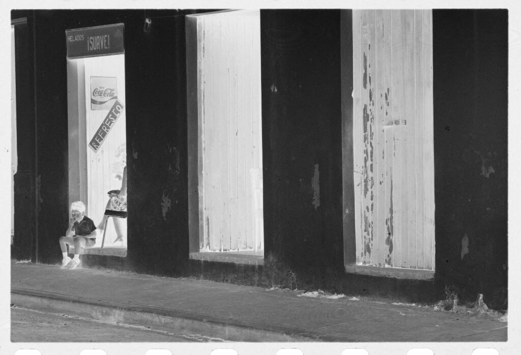 Untitled (Storefront With Boy Sitting In Doorway)