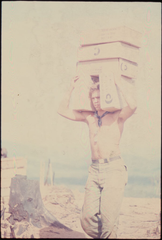 Untitled (Soldier Carrying Cargo Boxes On Head And Shoulders, Vietnam)