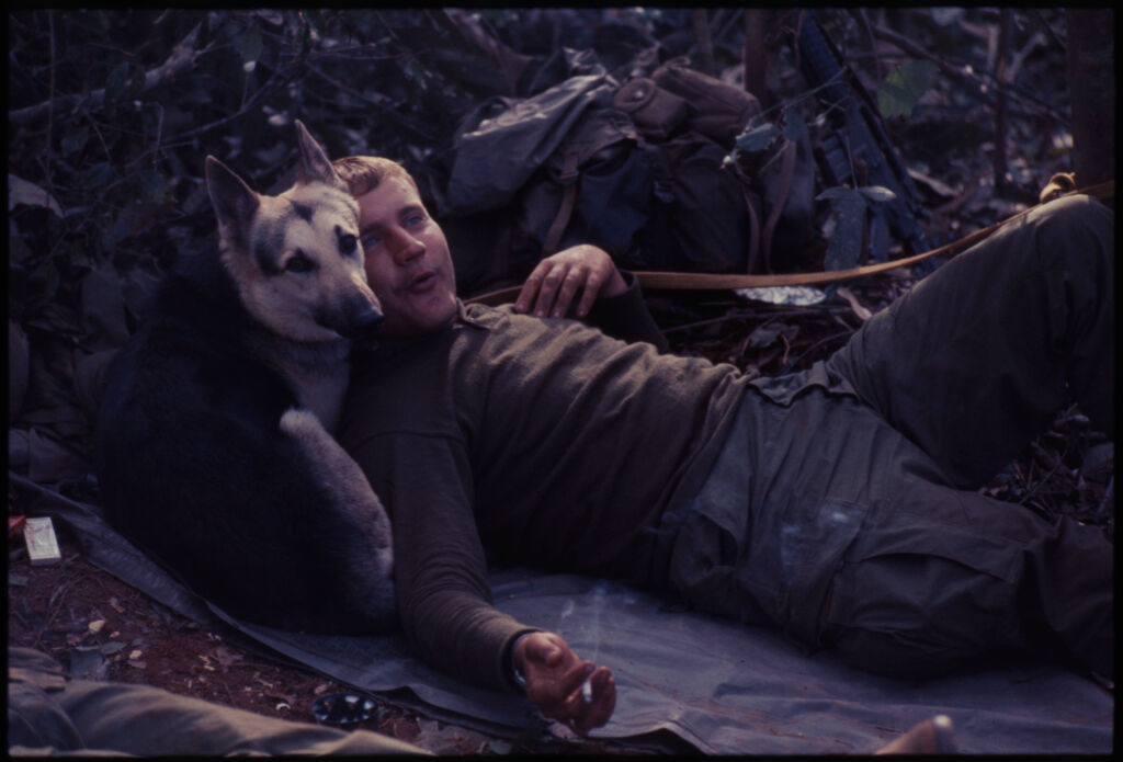 Untitled (Soldier Resting On Ground With Dog Laying Down Behind His Shoulders, Central Highlands Near Dak To, Vietnam)