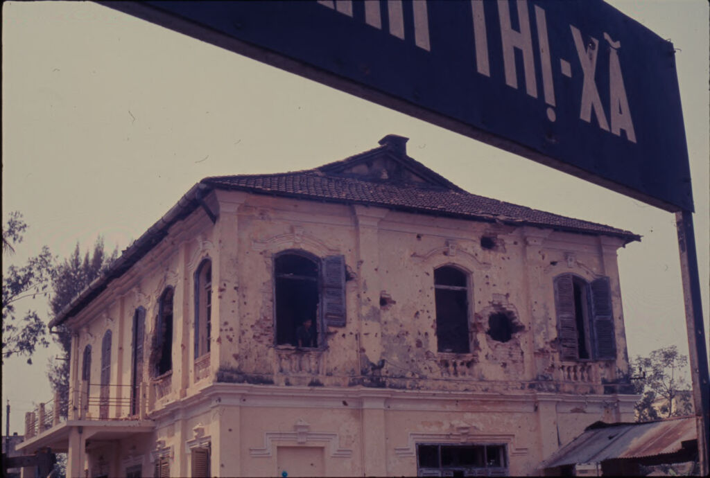 Untitled (Damaged Building Framed By Sign, Hue, Vietnam)