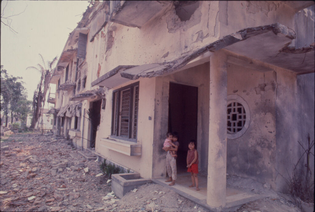 Untitled (Three Young South Vietnamese Children Outside Damaged Building On Debris-Filled Street, Hue, Vietnam)