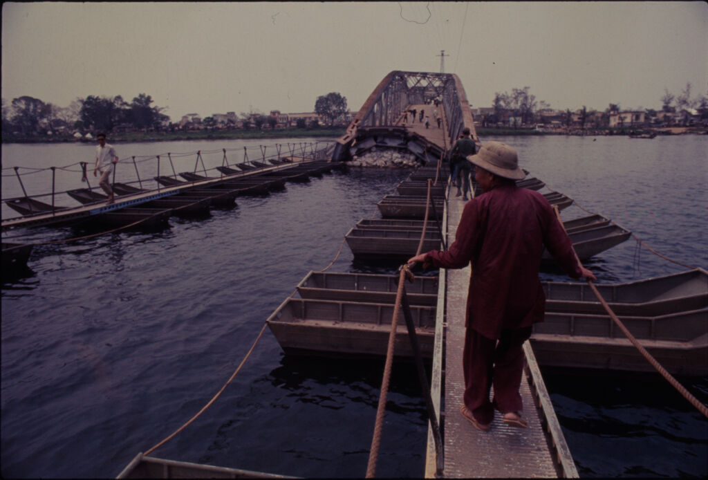 Untitled (Woman Crossing Floating Walkway In Center Section Of Collapsed Bridge, Perfume River, Hue, Vietnam)