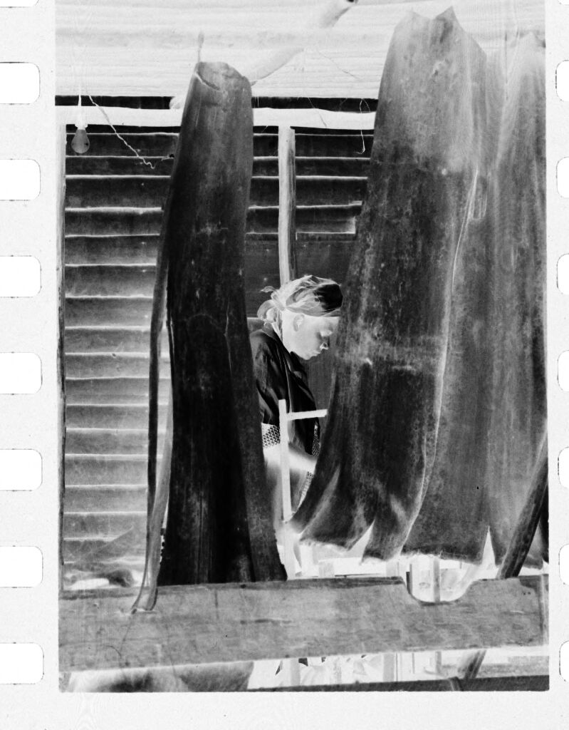 Untitled (Woman Working Behind Hanging Fabric)