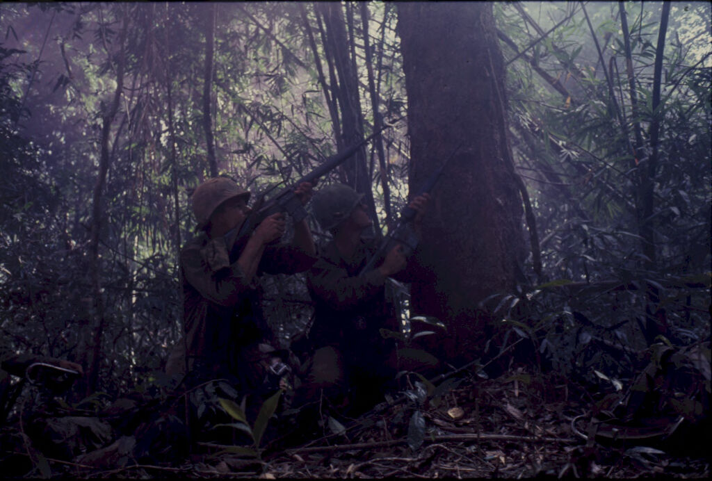 Untitled (Two Camouflaged Soldiers Aiming Guns Into Trees During Fighting In Central Highlands Near Dak To, Vietnam)