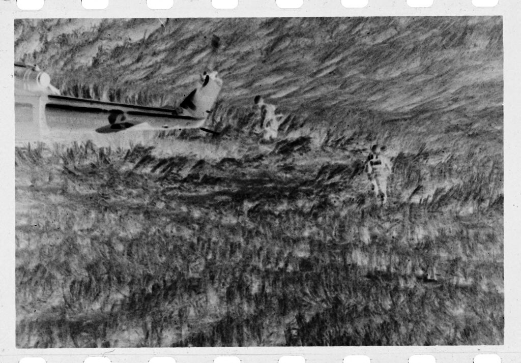 Untitled (Soldiers Standing In Field Near Tail Of Helicopter, Vietnam)