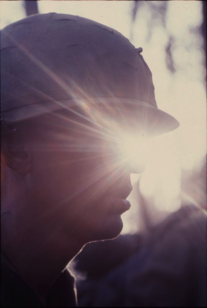 Untitled (Profile Of Soldier In Camouflage Helmet And Sunglasses Against Sun Glare, Central Highlands Near Dak To, Vietnam)