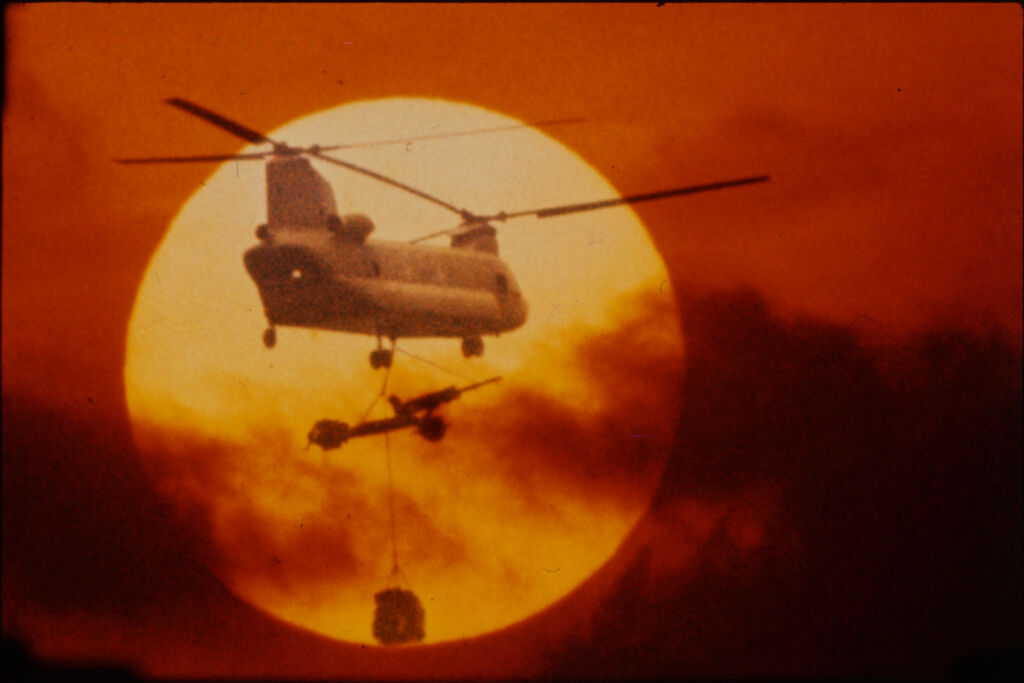 Untitled (Chinook Helicopter Lifting 105Mm Howitzer Silhouetted Against Sun, Vietnam)