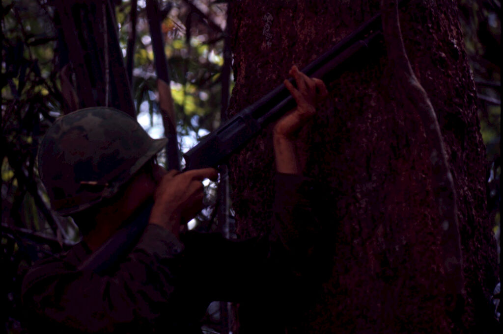 Untitled (Soldier Aiming Gun Into Trees During Fighting In Central Highlands Near Dak To, Vietnam)