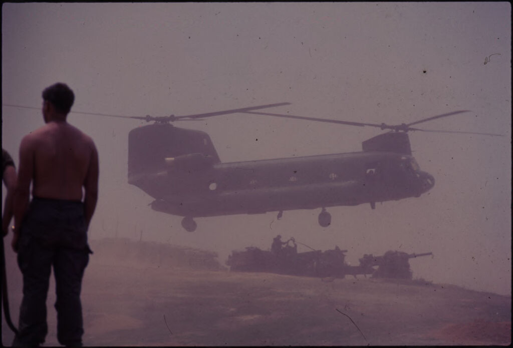 Untitled (Chinook Helicopter Lifting 105Mm Howitzer, Soldier Standing In Left Foreground, Vietnam)