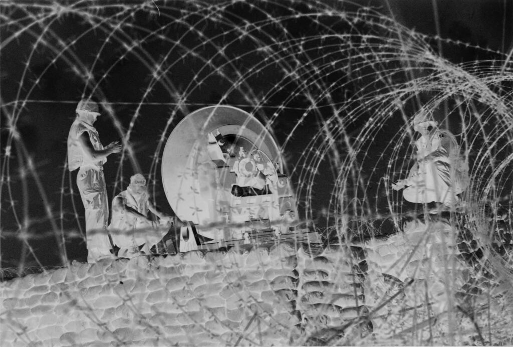 Untitled (Soldiers With Satellite Dish(?) Behind Barbed Wire, Vietnam)
