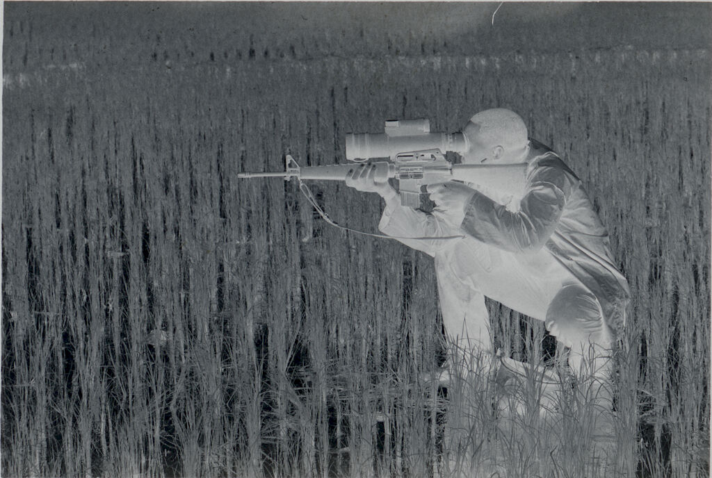 Untitled (Soldier Crouched In Rice Paddy Aiming Rifle Looking Though Sight Attachment, Vietnam)