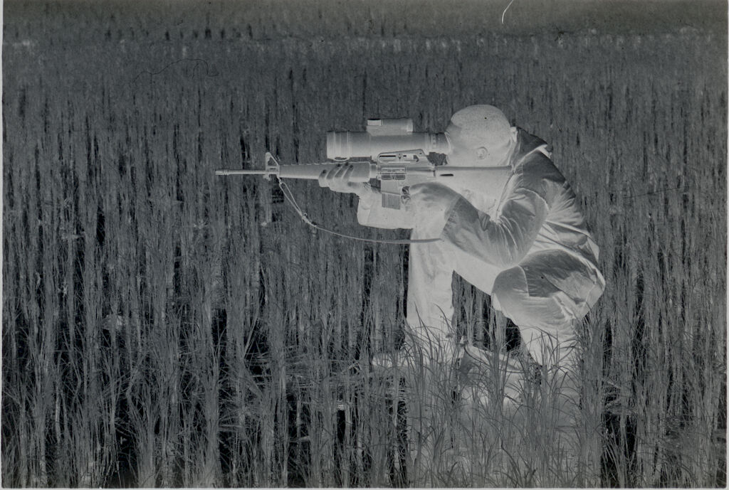 Untitled (Soldier Crouched In Rice Paddy Aiming Rifle Looking Though Sight Attachment, Vietnam)