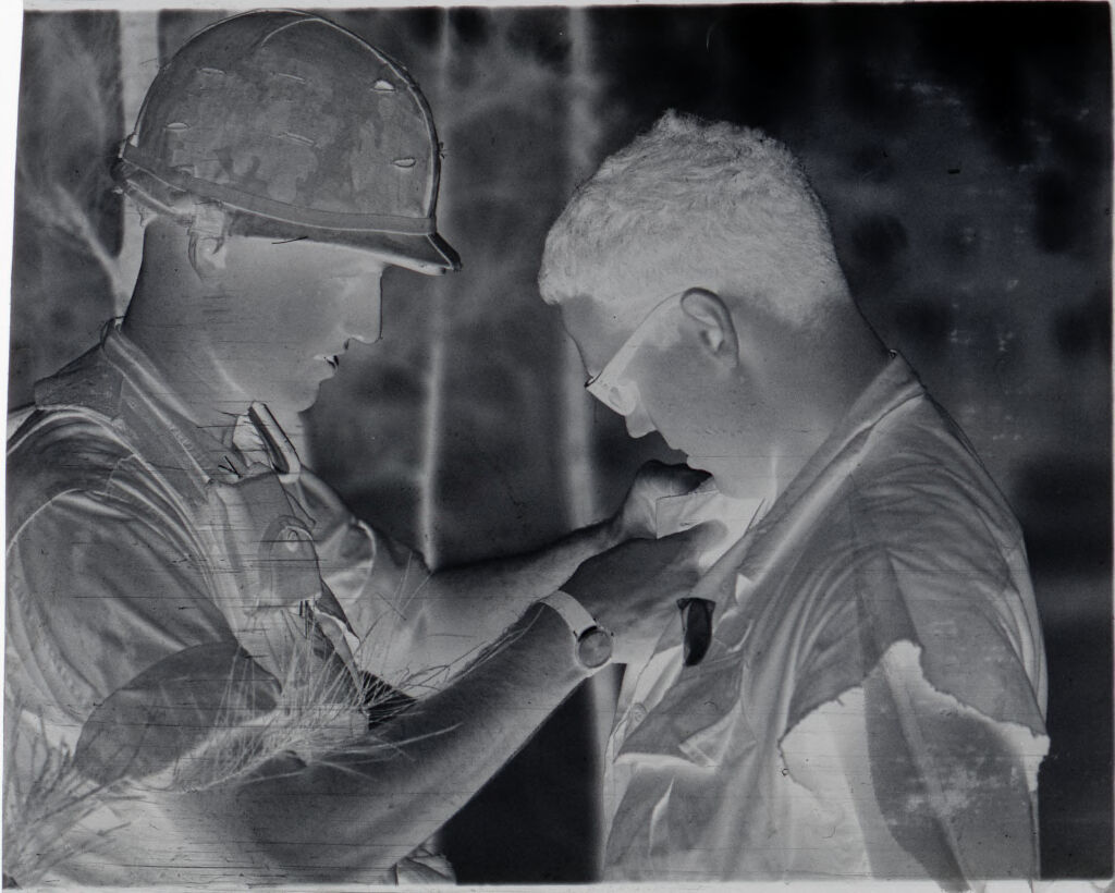 Untitled (Soldier Pinning Something On Another Soldier's Shirt, Vietnam)