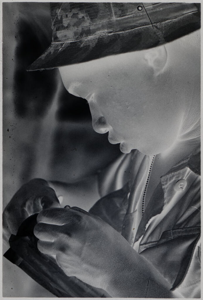 Untitled (Soldier In Camouflage Hat Writing In Notebook, Vietnam)