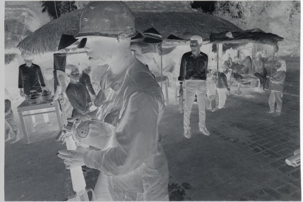 Untitled (Soldiers Milling Around In Front Of Thatched Huts, Vietnam)