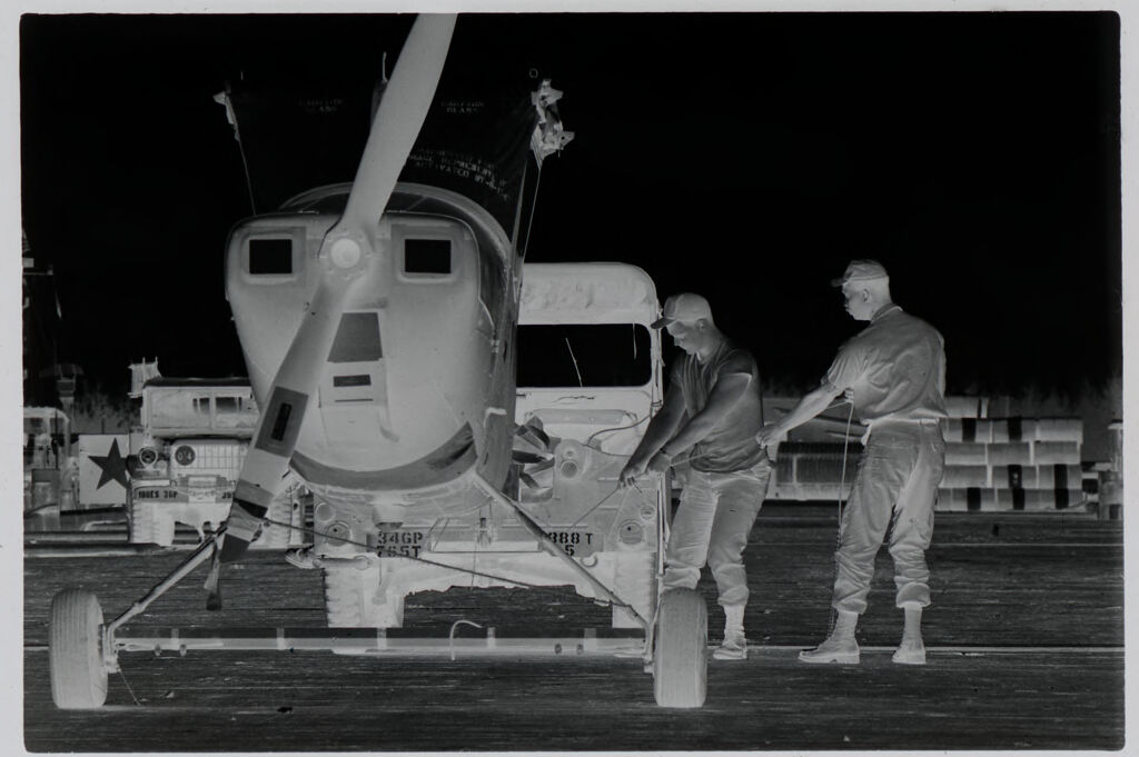 Untitled (Two Soldiers Pulling On Cord Attached To Grounded Helicopter, Vietnam)